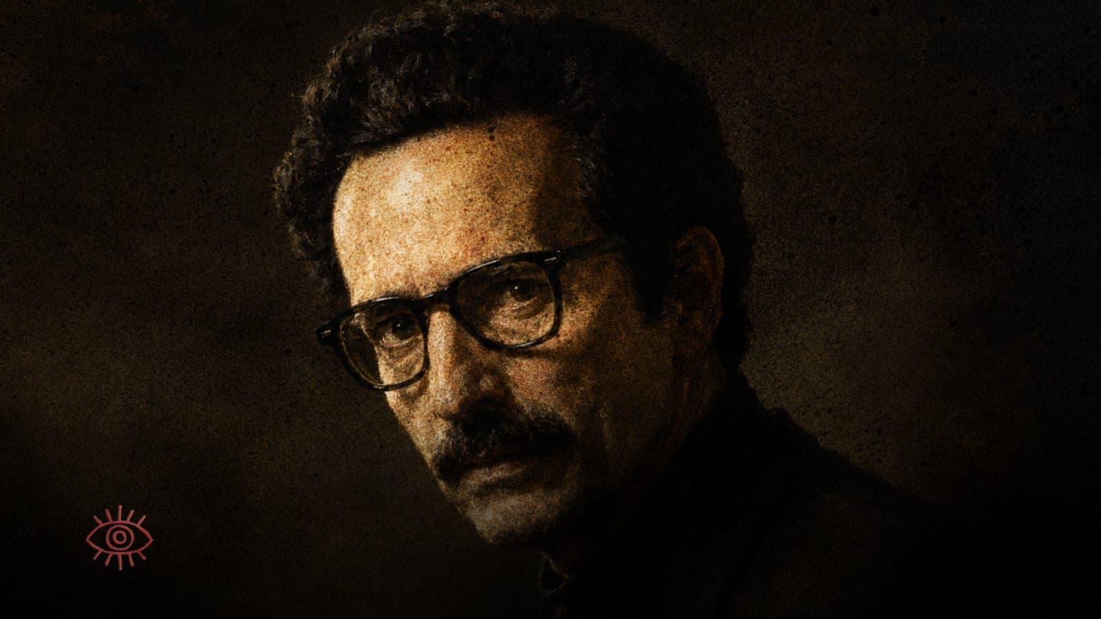 A somber portrait of Ernest Becker in black glasses and dark clothing, warmly lit against a dark background.